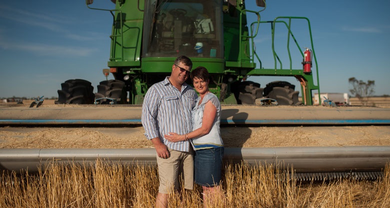 Mark and Merridee Schilling stand in front of farm machinery