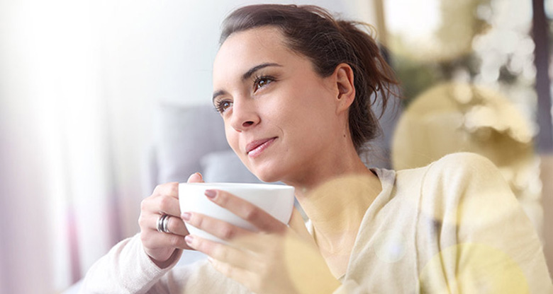Thinking woman with cup of coffee