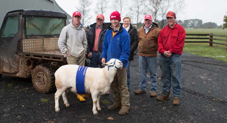 family of farmers standing with a prize winning sheep