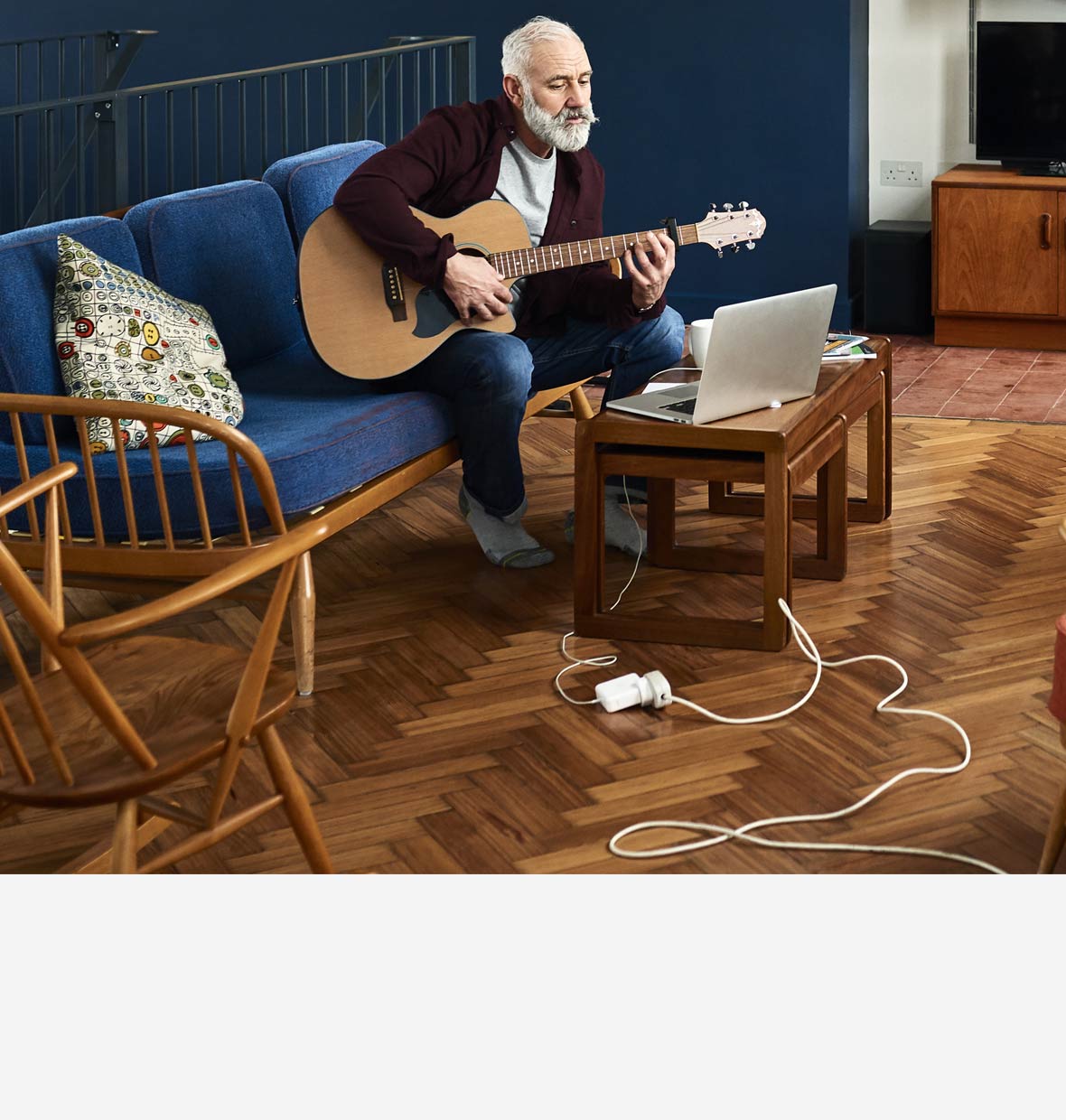 Man playing guitar in his lounge