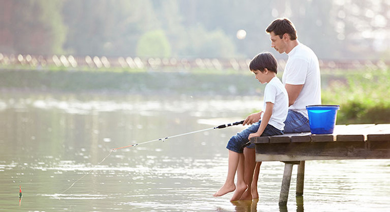 Father fishing with son on lake