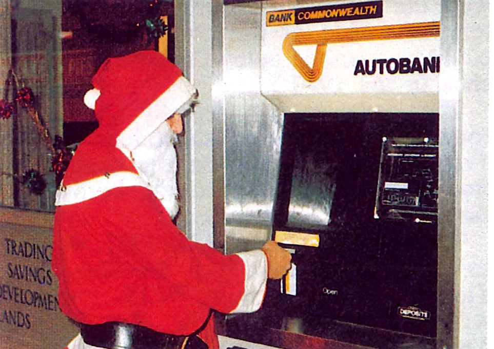 Santa grabs some cash from a "mechanical teller"