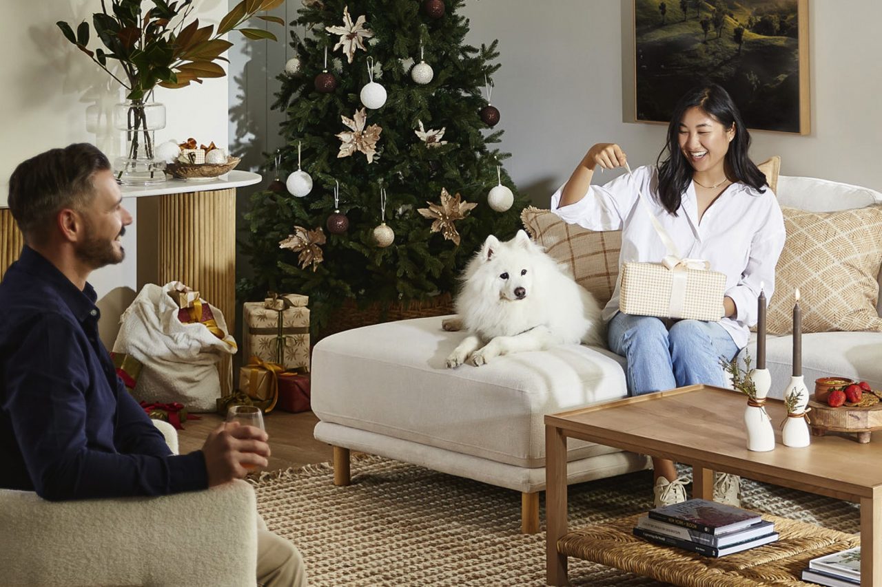 A couple sitting opening presents