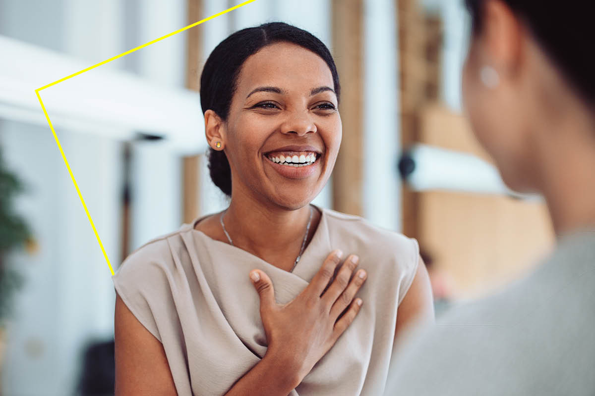 Aerial view of a car driving on a long road by the ocean