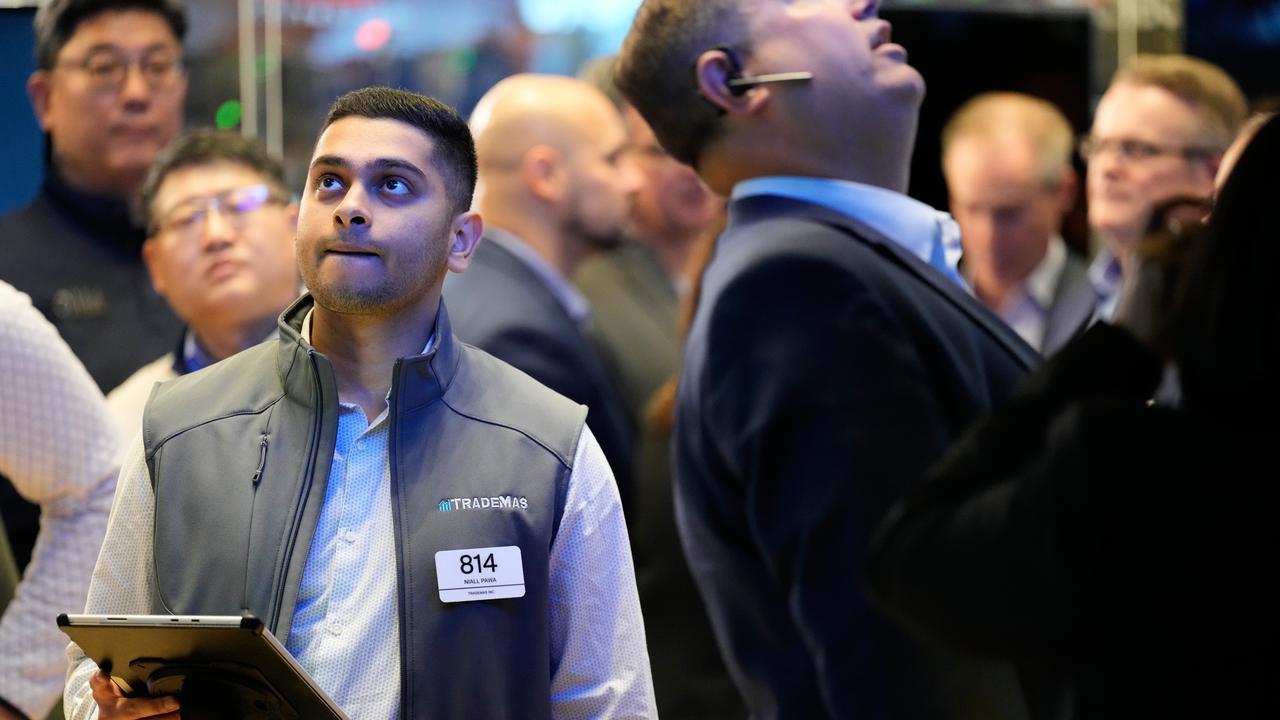 A trader looks at screens on the Wall Street trading floor