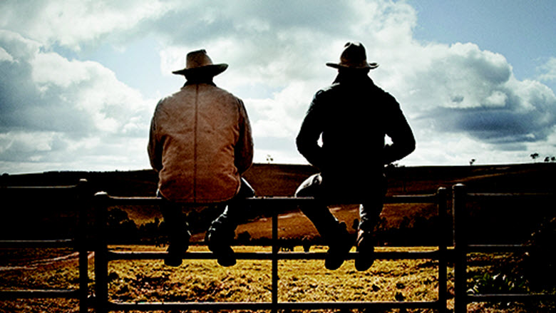 Australian farmers sitting on paddock fencing