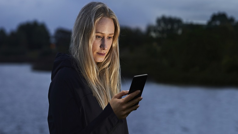 woman in dark with phone