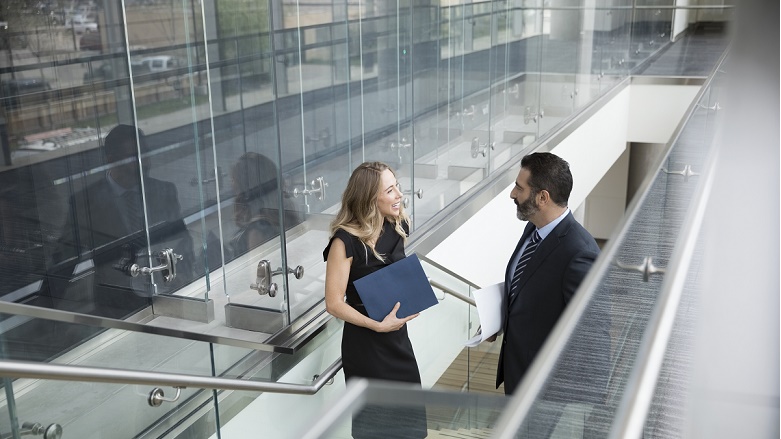 Two business people talk on stairs