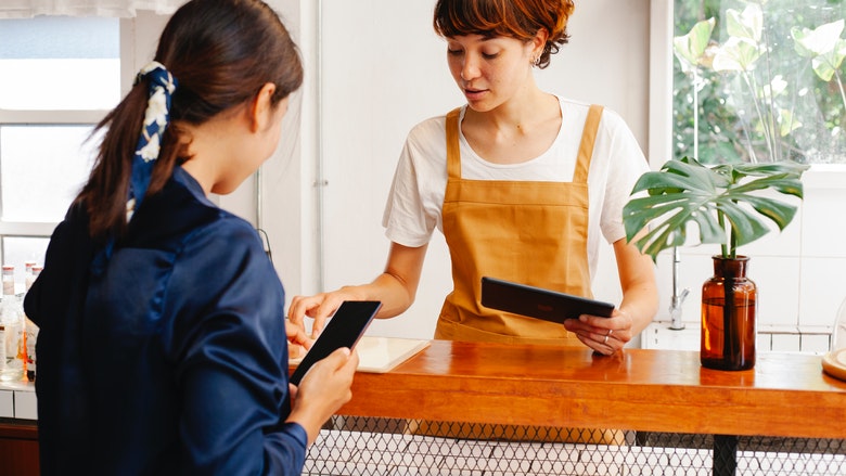 Two women talk over counter