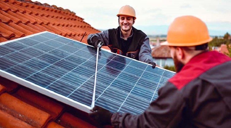 Image of people installing solar pannels on a roof