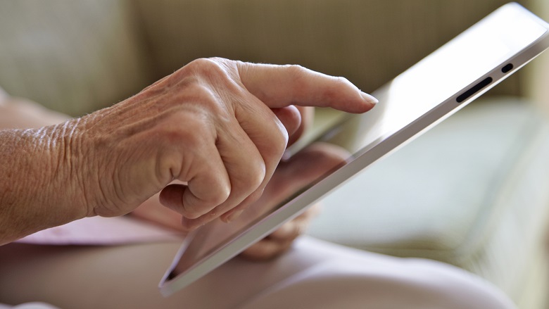 aged person looking at tablet screen