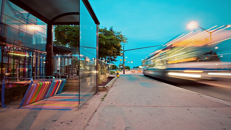 blurred bus pulling away from bus stop