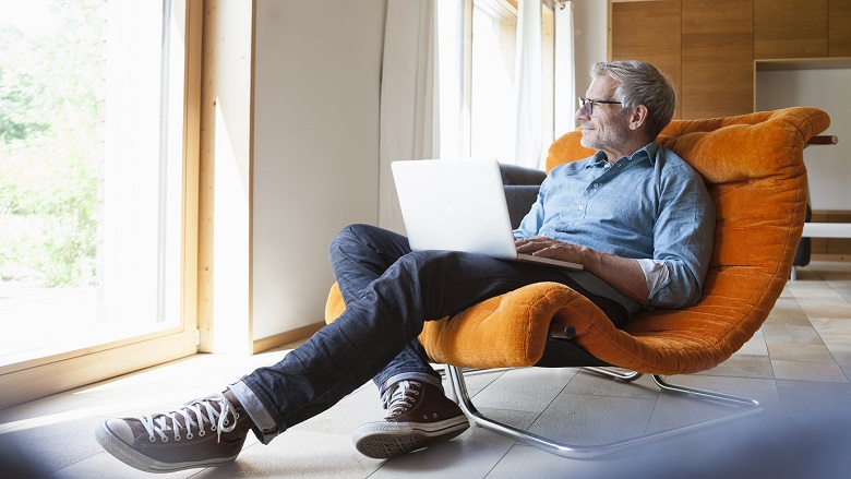 Man looking out window with laptop