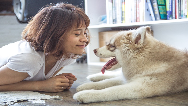 Woman and her dog lying on living room floor