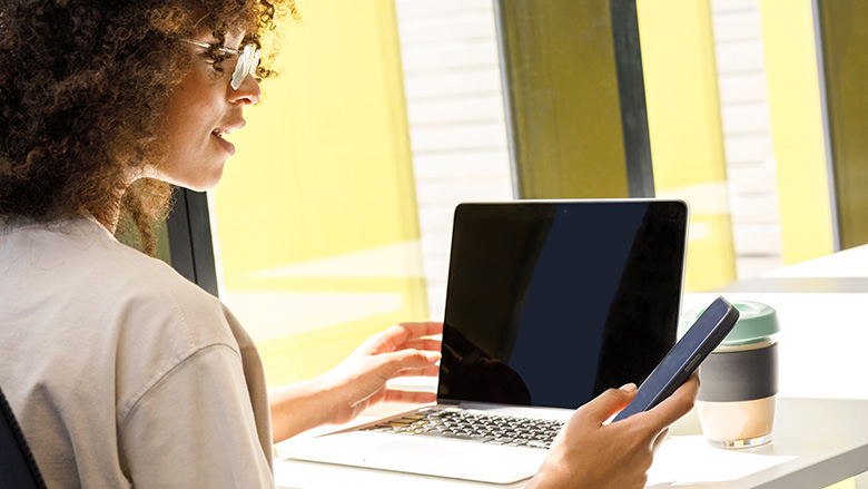 Woman using smartphone and computer