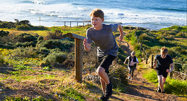 Boy running up a sandhill