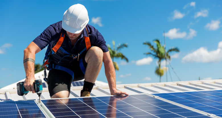 Man installing solar panels on a roof