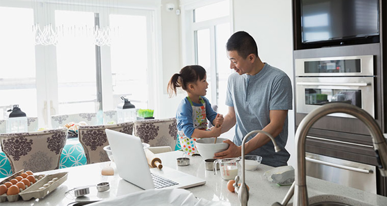 A father and his young daugher cooking a meal in their apartment