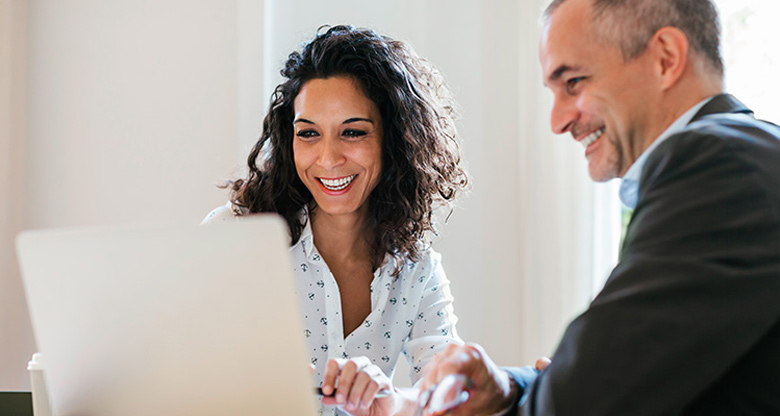 man and woman looking at laptop