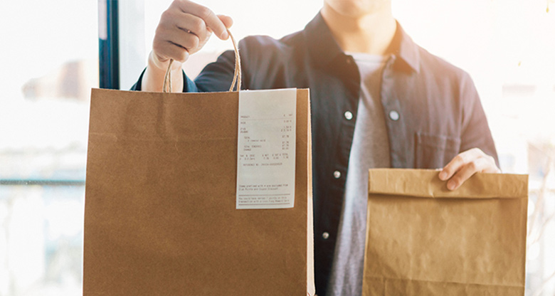 Fast food retailer with bags of takeaway food