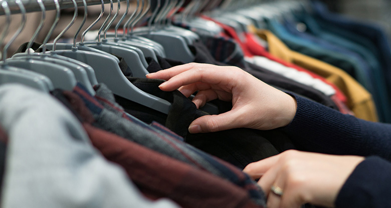 Customer looking through a rack of clothes