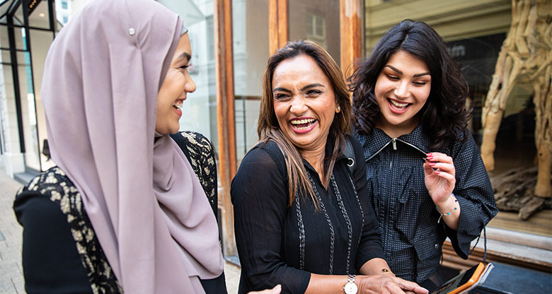 Women laugh while paying in store