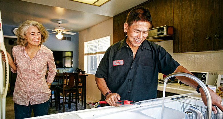 A plumber working at the home of a happy customer