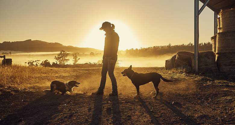 A woman with her two dogs on her farm