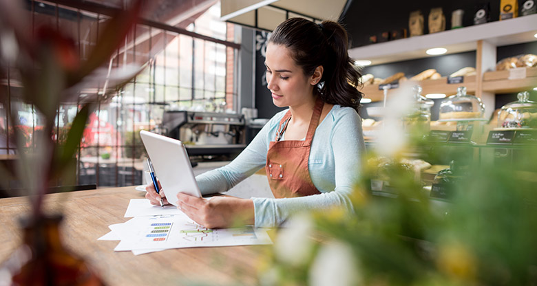 Business owner working with laptop and paperwork