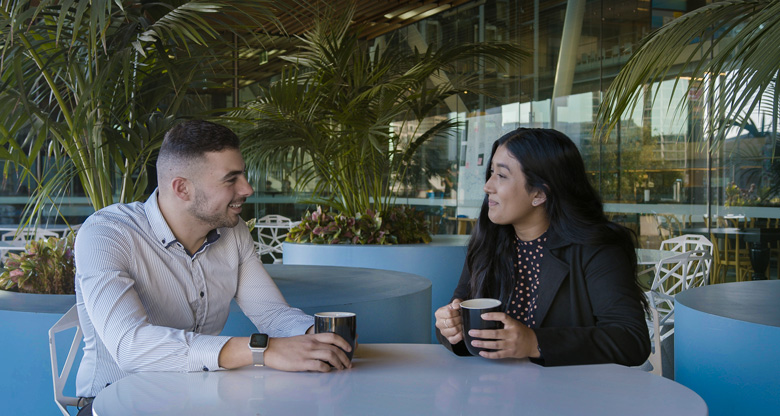 Hena having coffee with co-worker