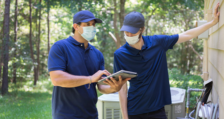 Two building and pest inspectors wearing masks in action