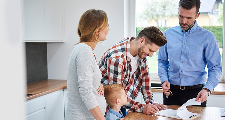 Family signing contract in kitchen