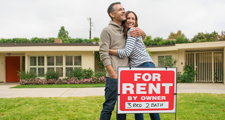 Couple in front of "for rent" sign