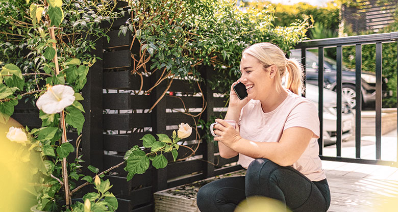 Woman talking on the phone outside in the garden