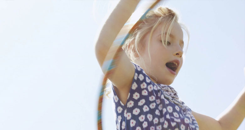 Image of a little girl outside playing in the sunshine