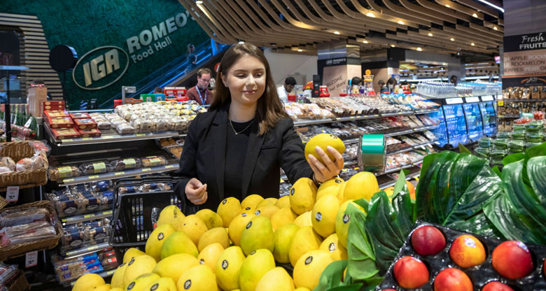 Image of a woman buying lemons in a grocery store