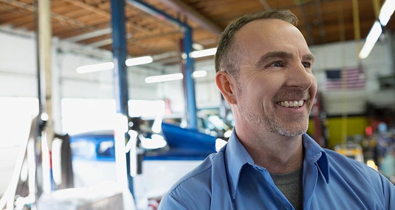 man smiling in car workshop