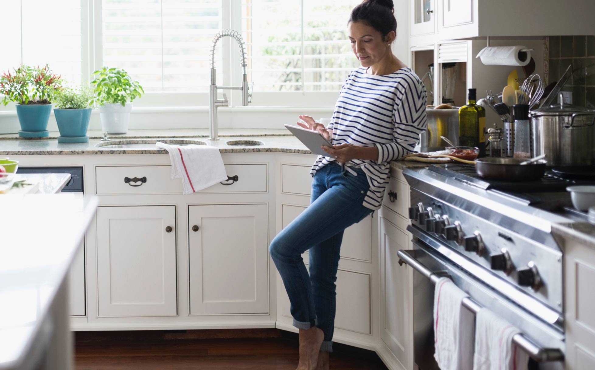 woman in kitchen on tablet screen