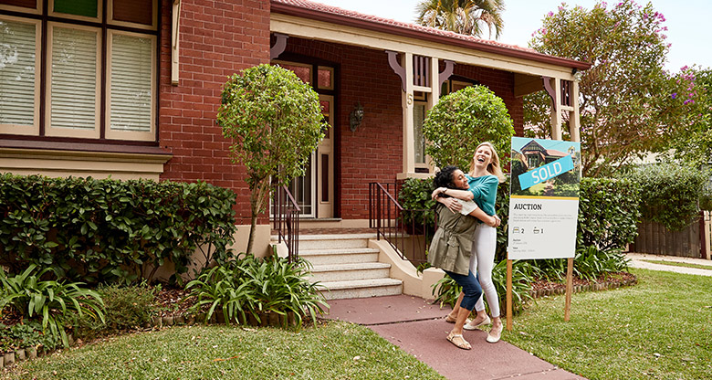 Successful auction buyers in front of house