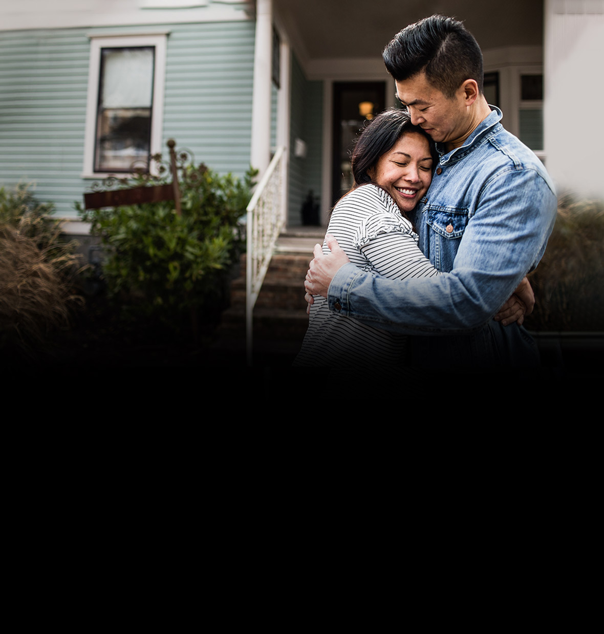 Young couple in front of their new house