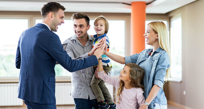 Real estate agent high-fiving happy family