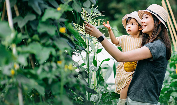 woman and son looking at plants