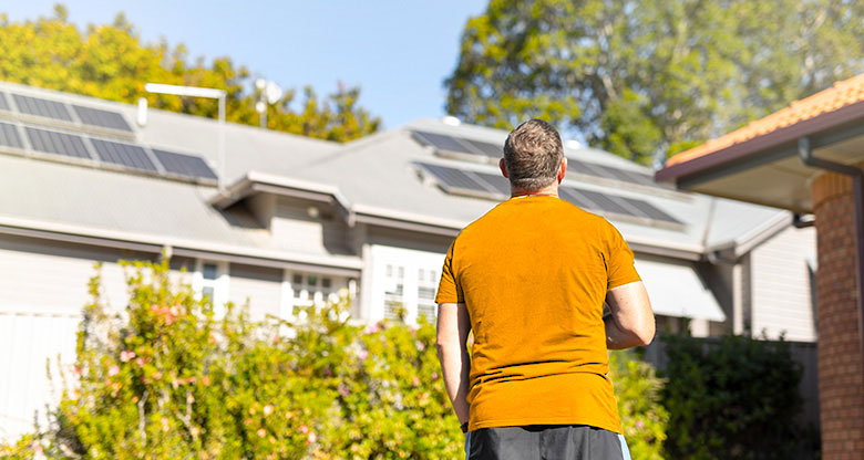 Back of man looking at roof solar panels