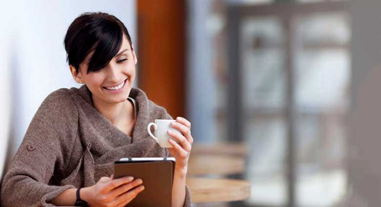 Young woman reading her ipad on a coffee break