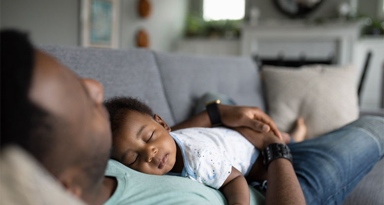 Father holding sleeping baby