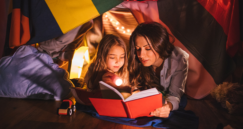 Mother and daughter camping at night