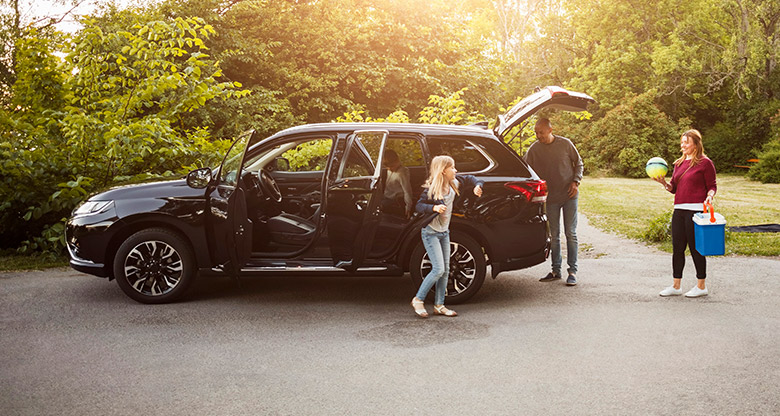 Family unpacking car on road trip