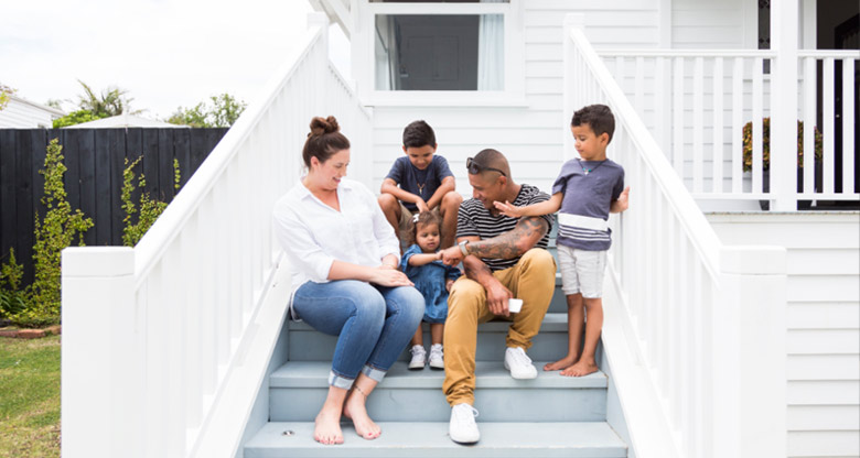 Family sitting outside house