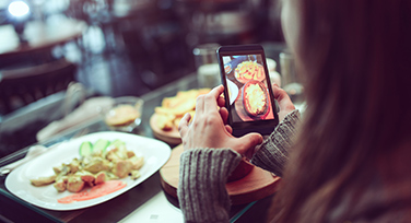 Girl taking photo of delicious food