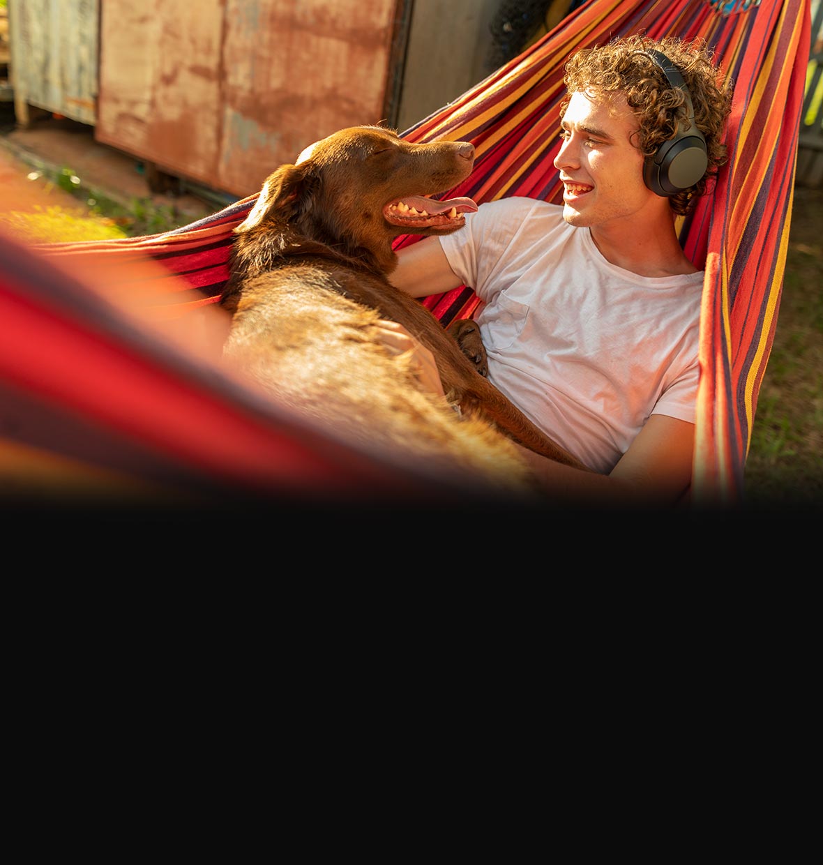 man with headphones on with his dog